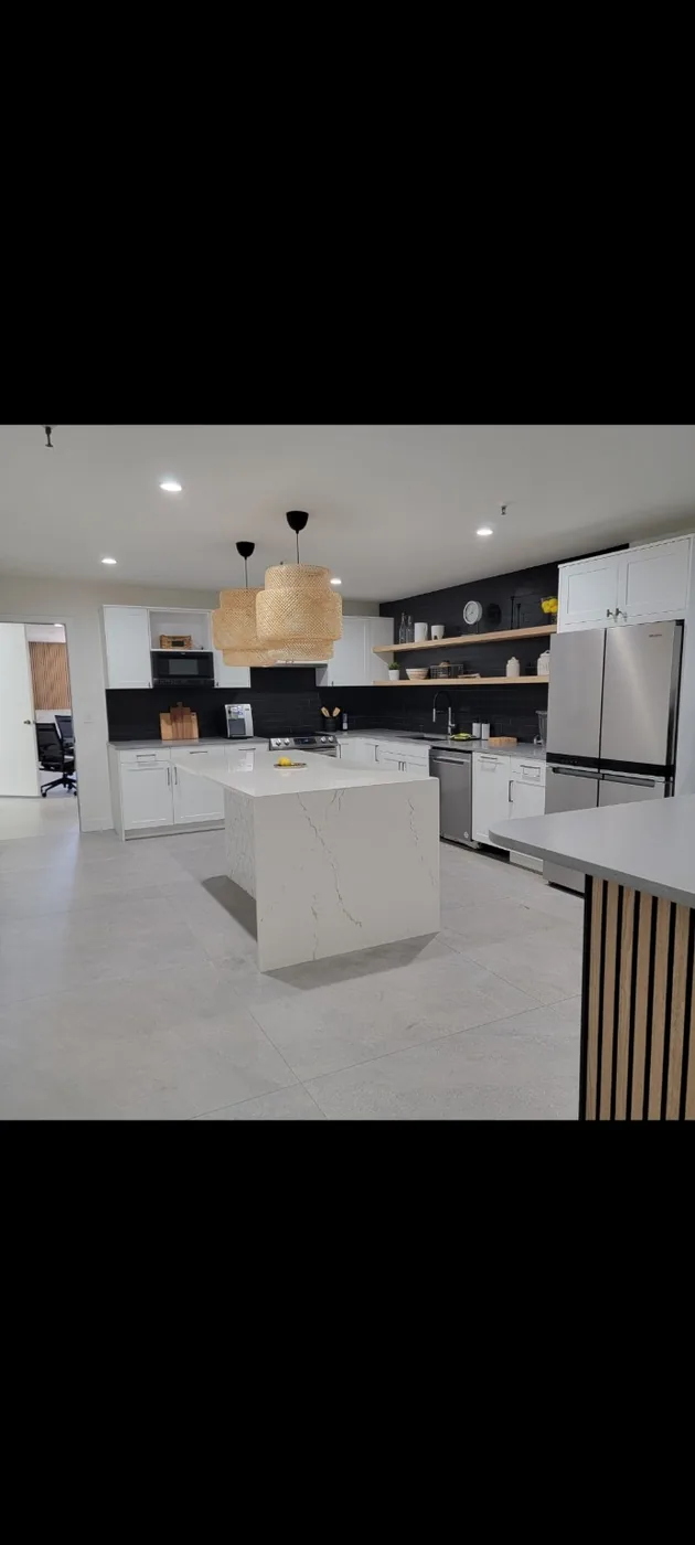 White kitchen cabinets with black backsplash